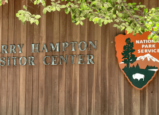 Photo of Harry Hampton Visitor Center sign at Congaree with National Park Service emblem