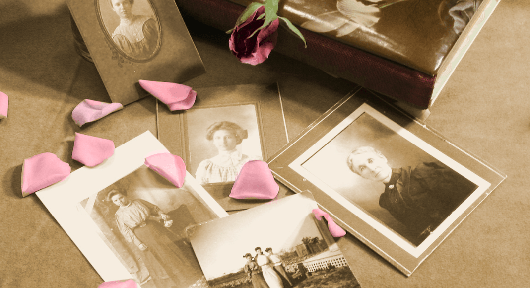 Old photographs of moms who made history laid out across a table with rose petals scattered around.